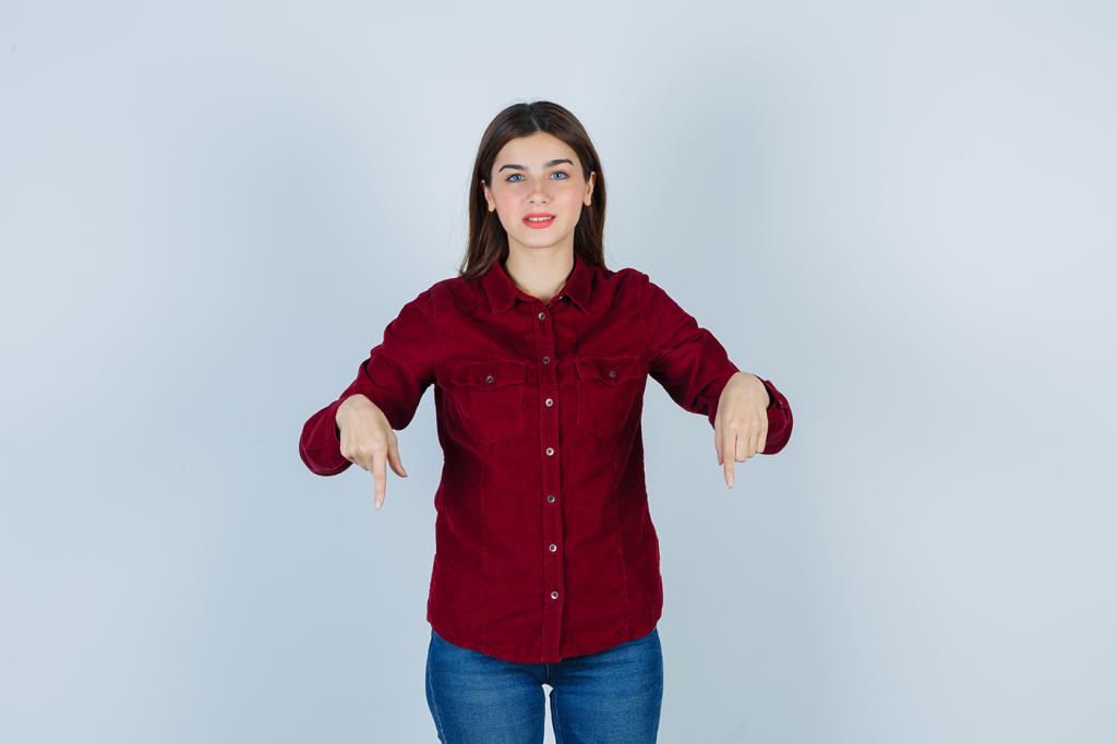 A girl smiling and pointing downward, symbolizing humility and guidance in faith