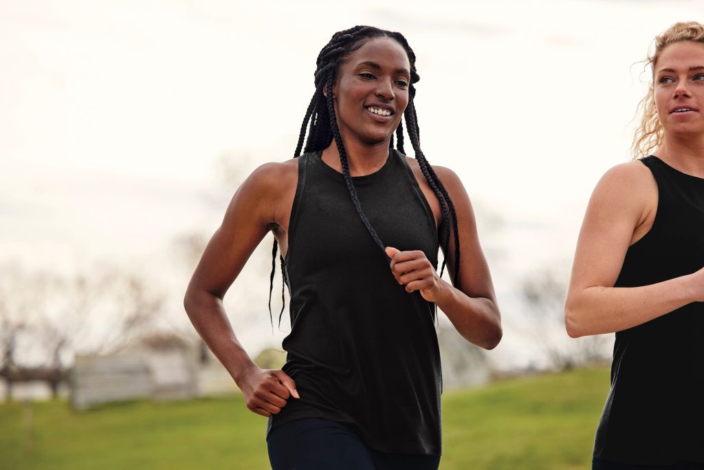 Female runner wearing Sport-Tek LST402 Tri-Blend Wicking Tank, built for breathable comfort and all-day movement.