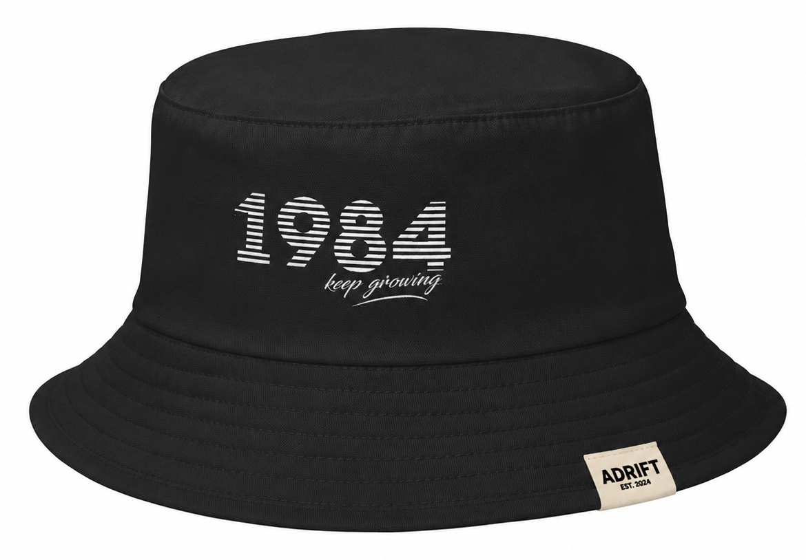 AS Colour Bucket Hat 1171 featuring a custom DTF print and a folded woven label in an Apliiq-generated mockup.