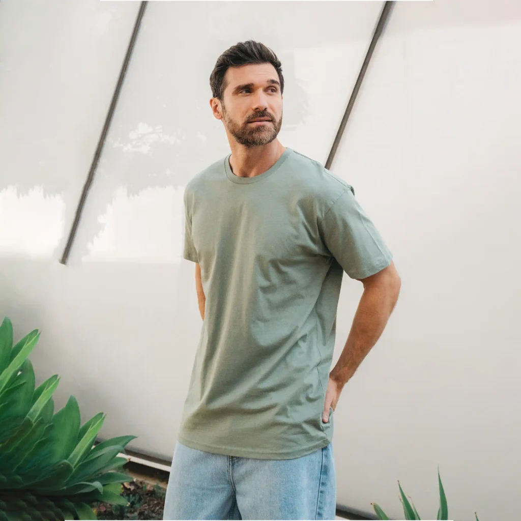 Man wearing a seafoam Cotton Heritage MC1082 men's premium short sleeve T-shirt with light blue jeans.
